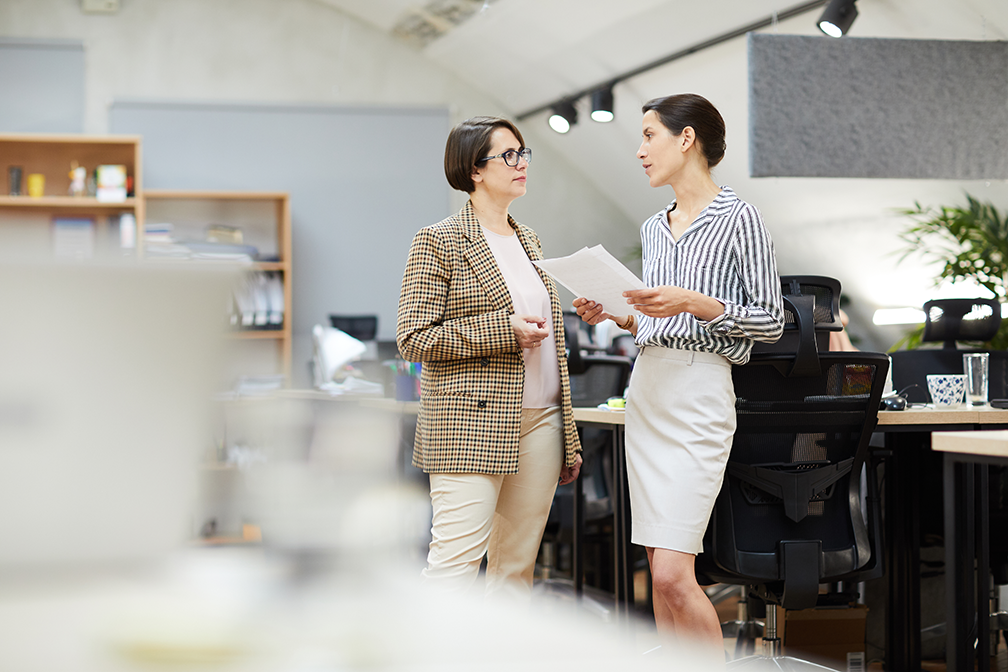 Two businesswomen discussing work in office
